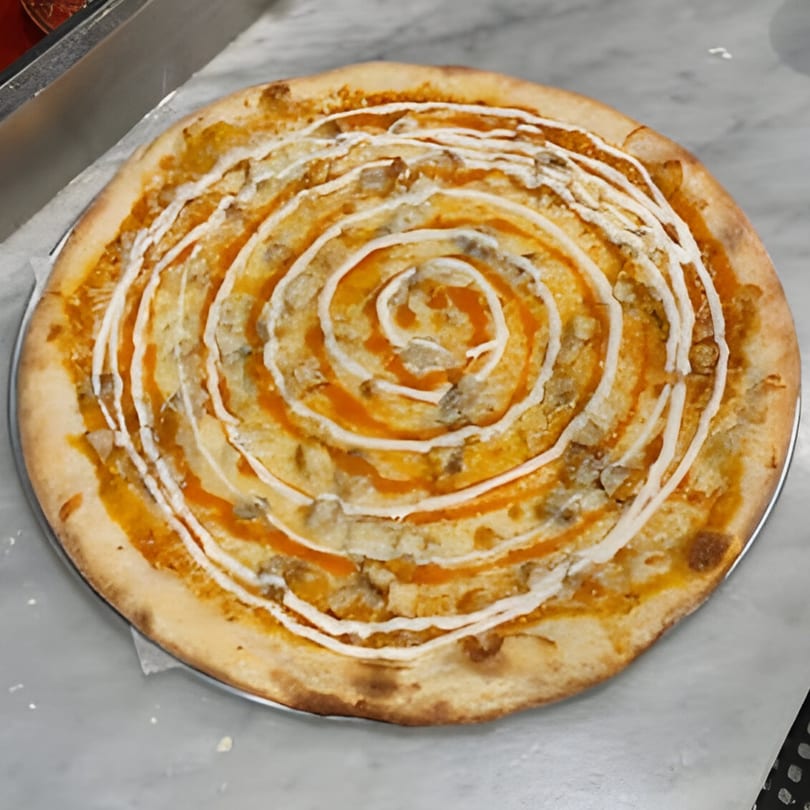 Jonuzi Southside Pizza's buffalo chicken pizza with a spiral of white and orange sauces.