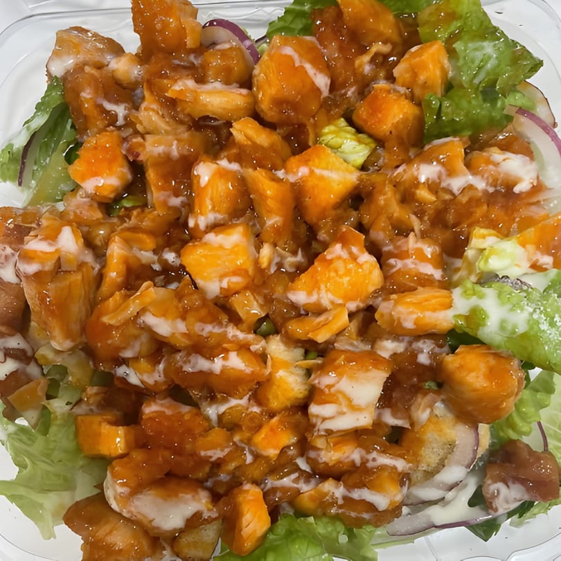 Jonuzi Southside Pizza's salad with crispy chicken pieces, lettuce, red onion, and creamy dressing.