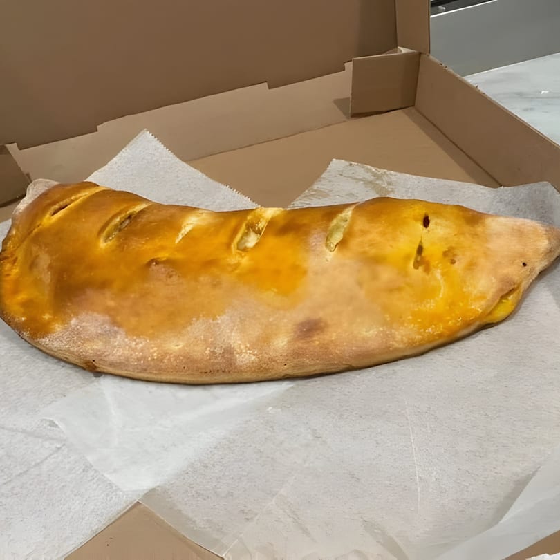 A golden-brown calzone from Jonuzi Southside Pizza, served in an open cardboard box.