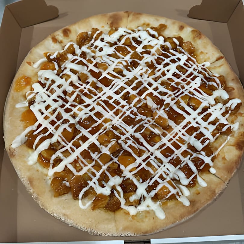 Jonuzi Southside Pizza's dessert pizza with diced fruit and a white icing drizzle in a box.